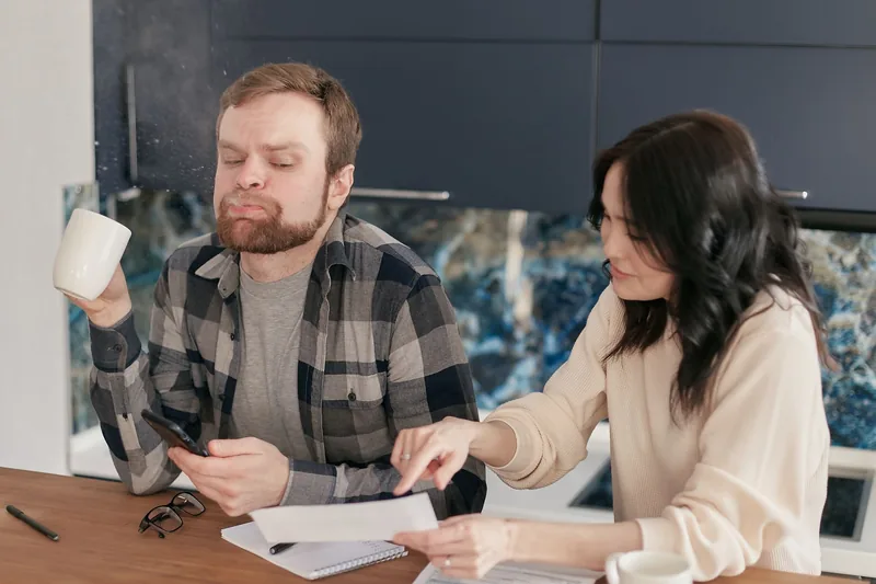 Two people going through a bill at the kitchen counter